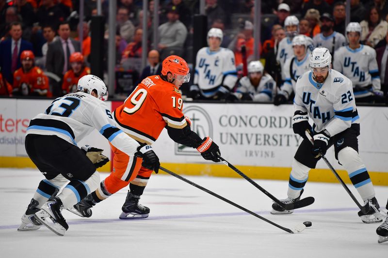 Dec 3, 2025; Anaheim, California, USA; Anaheim Ducks right wing Troy Terry (19) moves the puck against Utah Mammoth left wing Michael Carcone (53) and center Jack McBain (22) during the first period at Honda Center. Mandatory Credit: Gary A. Vasquez-Imagn Images
