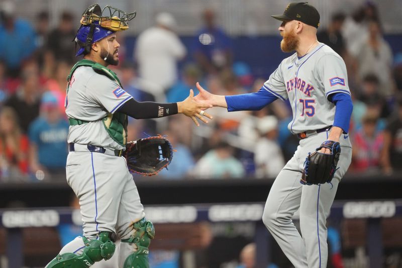 May 19, 2024; Miami, Florida, USA;  New York Mets catcher Omar Narváez (2) congratulates relief pitcher Reed Garrett (75) following a victory over the Miami Marlins at loanDepot Park. Mandatory Credit: Jim Rassol-USA TODAY Sports