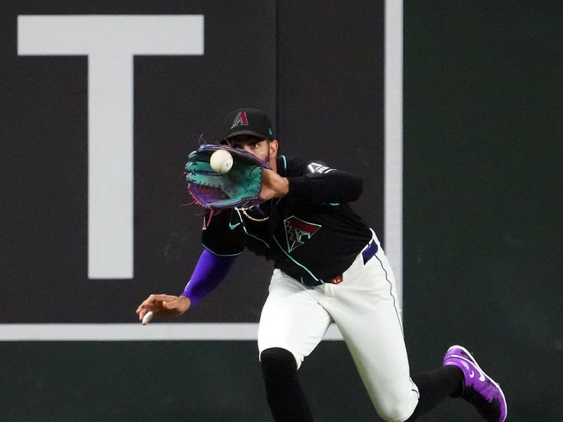 Aug 8, 2024; Phoenix, Arizona, USA; Arizona Diamondbacks outfielder Lourdes Gurriel Jr. (12) makes a catch against the Philadelphia Phillies during the third inning at Chase Field. Mandatory Credit: Joe Camporeale-USA TODAY Sports