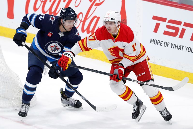 Apr 4, 2024; Winnipeg, Manitoba, CAN; Calgary Flames center Yegor Sharangovich (17) skates up the ice past Winnipeg Jets defenseman Brenden Dillon (5) in the third period at Canada Life Centre. Mandatory Credit: James Carey Lauder-USA TODAY Sports