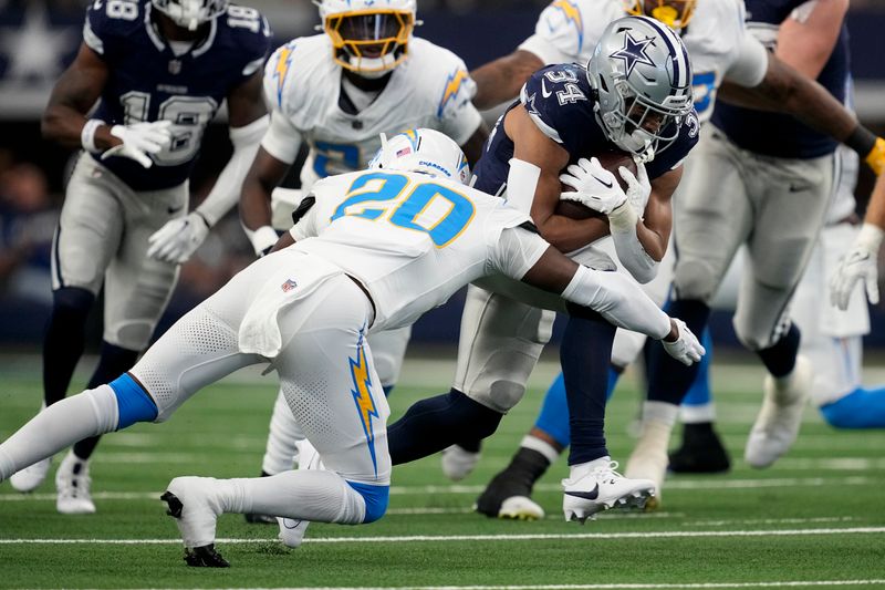 Dallas Cowboys running back Malik Davis (34) is tackled by Los Angeles Chargers cornerback Cam Hart (20) during the first half of a preseason NFL football game, Saturday, Aug. 24, 2024, in Arlington, Texas.(AP Photo/Tony Gutierrez )