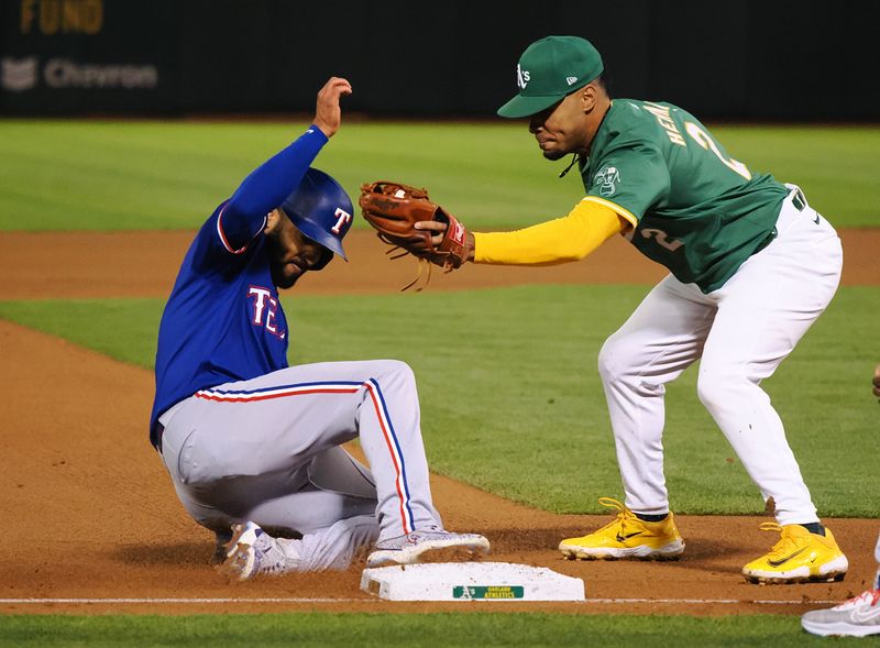 Sep 25, 2024; Oakland, California, USA; Texas Rangers second baseman Marcus Semien (2) safe at third base against Oakland Athletics third baseman Darell Hernaiz (2) during the fourth inning at Oakland-Alameda County Coliseum. Mandatory Credit: Kelley L Cox-Imagn Images