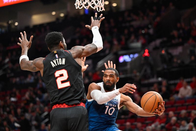 PORTLAND, OREGON - FEBRUARY 15: Mike Conley #10 of the Minnesota Timberwolves passes the ball around Deandre Ayton #2 of the Portland Trail Blazers during the first quarter at the Moda Center on February 15, 2024 in Portland, Oregon. NOTE TO USER: User expressly acknowledges and agrees that, by downloading and or using this photograph, User is consenting to the terms and conditions of the Getty Images License Agreement. (Photo by Alika Jenner/Getty Images)