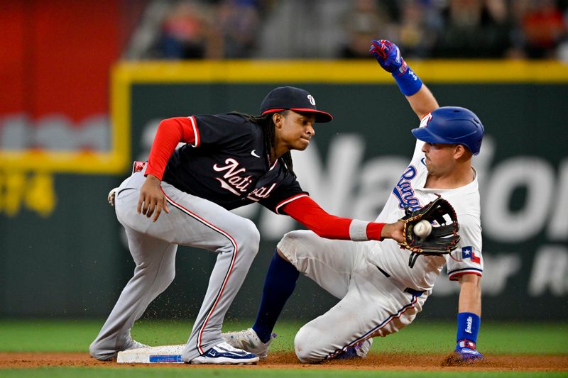 May 2, 2024; Arlington, Texas, USA; Texas Rangers first baseman Nathaniel Lowe (30) steals second base under the tag of Washington Nationals shortstop CJ Abrams (5) during the eighth inning at Globe Life Field. Mandatory Credit: Jerome Miron-USA TODAY Sports