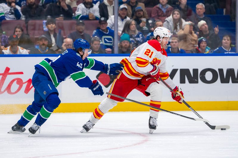 Nov 12, 2024; Vancouver, British Columbia, CAN; Vancouver Canucks defenseman Quinn Hughes (43) defends against Calgary Flames forward Kevin Rooney (21) during the first period at Rogers Arena. Mandatory Credit: Bob Frid-Imagn Images