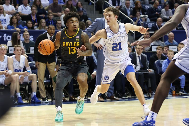 Feb 20, 2024; Provo, Utah, USA; Baylor Bears guard Langston Love (13) drives against Brigham Young Cougars guard Trevin Knell (21) during the first half at Marriott Center. Mandatory Credit: Rob Gray-USA TODAY Sports