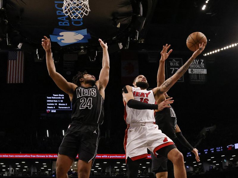 NEW YORK, NEW YORK - JANUARY 15:  Caleb Martin #16 of the Miami Heat shoots against Cam Thomas #24 of the Brooklyn Nets during their game at Barclays Center on January 15, 2024 in New York City.   User expressly acknowledges and agrees that, by downloading and or using this photograph, User is consenting to the terms and conditions of the Getty Images License Agreement.  (Photo by Al Bello/Getty Images)