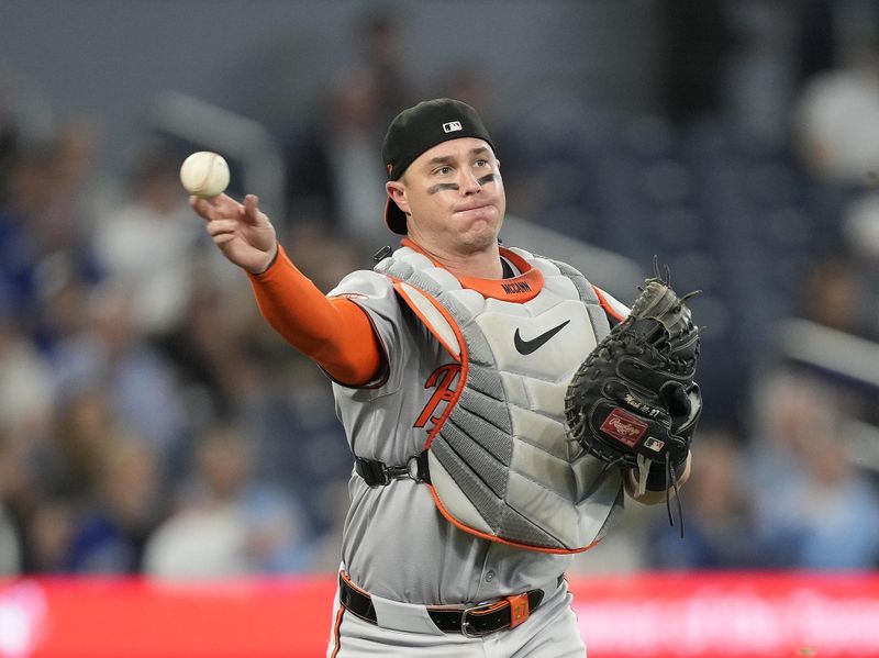 Jun 4, 2024; Toronto, Ontario, CAN;  Baltimore Orioles catcher James McCann (27) throws to first base to put out Toronto Blue Jays pinch hitter Alejandro Kirk (not pictured) during the ninth inning at Rogers Centre. Mandatory Credit: John E. Sokolowski-USA TODAY Sports