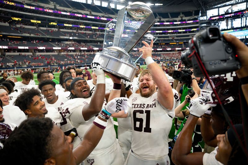 Sep 30, 2023; Arlington, Texas, USA; The Texas A&M Aggies celebrate with the Southwest Classic trophy after the Aggies victory over the Arkansas Razorbacks at AT&T Stadium. Mandatory Credit: Jerome Miron-USA TODAY Sports