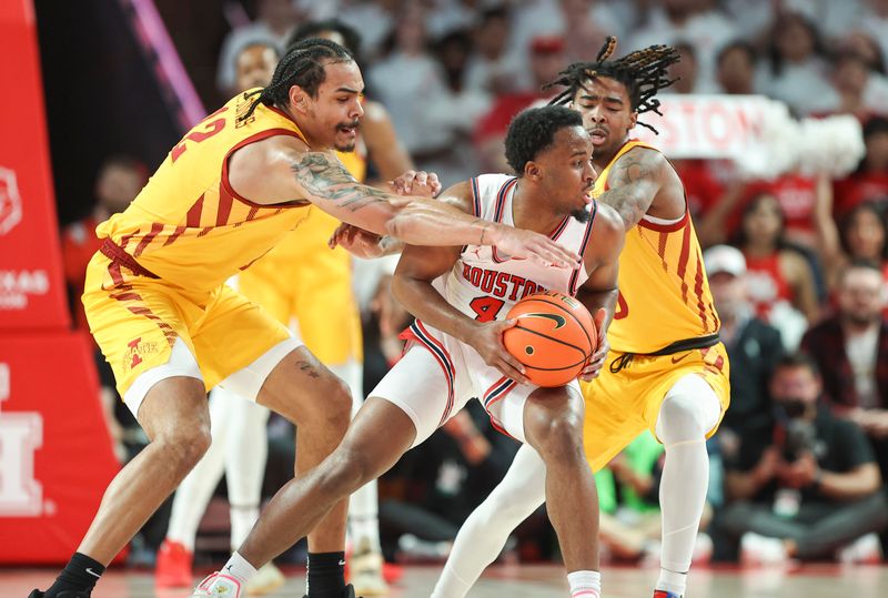 Feb 19, 2024; Houston, Texas, USA; Houston Cougars guard L.J. Cryer (4) controls the ball as Iowa State Cyclones forward Robert Jones (12) and guard Keshon Gilbert (10) defend during the game at Fertitta Center. Mandatory Credit: Troy Taormina-USA TODAY Sports