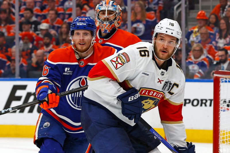 Jun 6, 2025; Edmonton, Alberta, CAN; Florida Panthers center Aleksander Barkov (16) and Edmonton Oilers defenseman John Klingberg (36) attempt to get the puck during the second period in game two of the 2025 Stanley Cup Final at Rogers Place. Mandatory Credit: Perry Nelson-Imagn Images