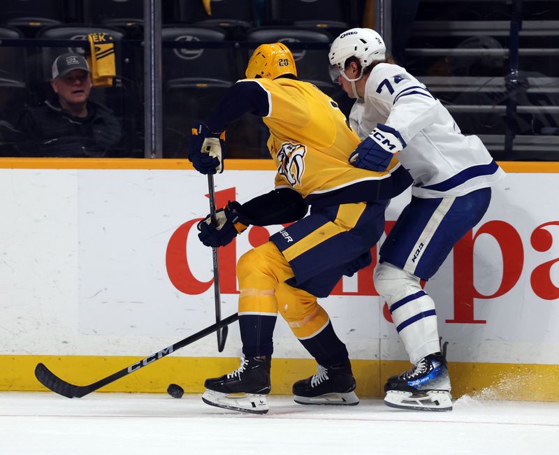 Mar 22, 2025; Nashville, Tennessee, USA; Nashville Predators defenseman Justin Barron (20) competes with Toronto Maple Leafs center Bobby McMann (74) for control of the puck during the second period of the game at Bridgestone Arena. Mandatory Credit: Alan Poizner-Imagn Images