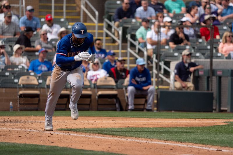 Mar 6, 2024; Salt River Pima-Maricopa, Arizona, USA; Texas Rangers infielder Ezequiel Duran (20) hustles to beat the throw to first in the fifth inning during a spring training game against  the Colorado Rockies at Salt River Fields at Talking Stick. Mandatory Credit: Allan Henry-USA TODAY Sports