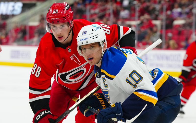 Nov 17, 2024; Raleigh, North Carolina, USA;  Carolina Hurricanes center Martin Necas (88) and St. Louis Blues center Brayden Schenn (10) watch the play during the third period at Lenovo Center. Mandatory Credit: James Guillory-Imagn Images