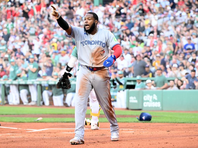 Jun 27, 2025; Boston, Massachusetts, USA; Toronto Blue Jays first baseman Vladimir Guerrero Jr. (27) reacts after being called out at home during the first inning against the Boston Red Sox at Fenway Park. The call was overturned to safe scoring a run for the Toronto Blue Jays after review. Mandatory Credit: Brian Fluharty-Imagn Images