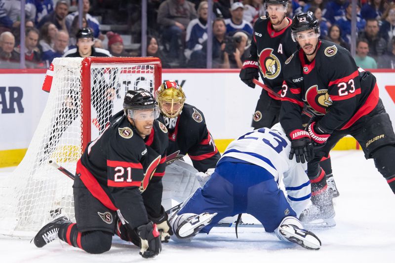 Feb 10, 2024; Ottawa, Ontario, CAN; Toronto Maple Leafs left wing Matthew Knies (23) goes down as he jockeys for position with Ottawa Senators right wing Mathieu Joseph (21) and defenseman Travis Hamonic (23) in the second period at the Canadian Tire Centre. Mandatory Credit: Marc DesRosiers-USA TODAY Sports