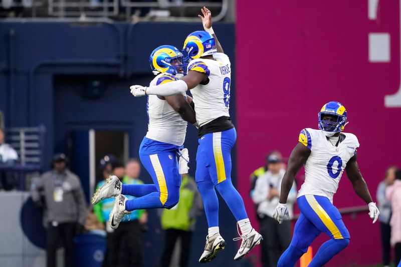 Los Angeles Rams defensive tackle Kobie Turner, left, celebrates with linebacker Jared Verse (8) during the second half of an NFL football game against the Seattle Seahawks in Seattle, Sunday, Nov. 3, 2024. (AP Photo/Lindsey Wasson)