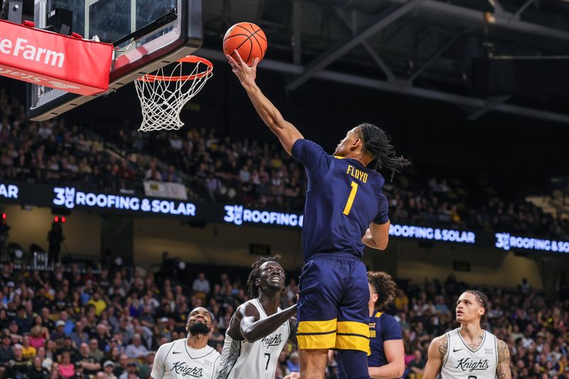 Feb 14, 2026; Orlando, Florida, USA; West Virginia Mountaineers guard Jasper Floyd (1) goes to the basket against UCF Knights center John Bol (7) during the first half at Addition Financial Arena. Mandatory Credit: Mike Watters-Imagn Images