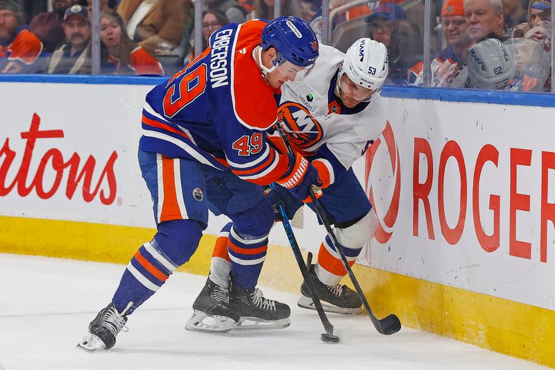 Jan 15, 2026; Edmonton, Alberta, CAN; Edmonton Oilers defensemen Ty Emberson (49) and New York Islanders forward Casey Cizikas (53) battle along the boards for a loose puck during the second period at Rogers Place. Mandatory Credit: Perry Nelson-Imagn Images