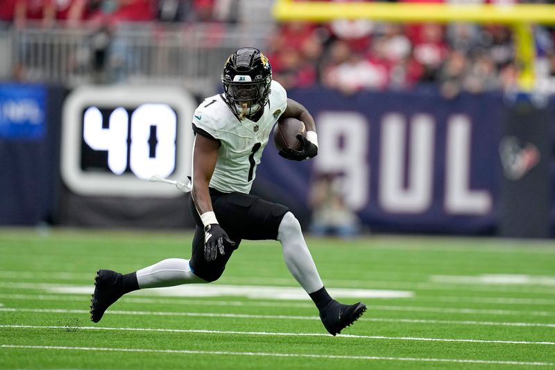 Jacksonville Jaguars running back Travis Etienne Jr. (1) carries the ball in the first half of an NFL football game against the Houston Texans in Houston, Sunday, Nov. 26, 2023. (AP Photo/Eric Gay)