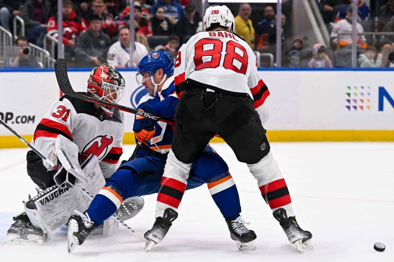 Mar 24, 2024; Elmont, New York, USA;  New Jersey Devils defenseman Kevin Bahl (88) checks New York Islanders right wing Cal Clutterbuck (15) in front of New Jersey Devils goaltender Kaapo Kahkonen (31) during the second period at UBS Arena. Mandatory Credit: Dennis Schneidler-USA TODAY Sports