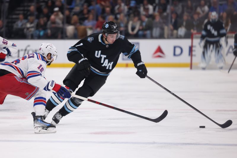 Jan 16, 2025; Salt Lake City, Utah, USA; Utah Hockey Club defenseman Michael Kesselring (7) reaches for the puck against New York Rangers center Vincent Trocheck (16) during the second period at Delta Center. Mandatory Credit: Rob Gray-Imagn Images