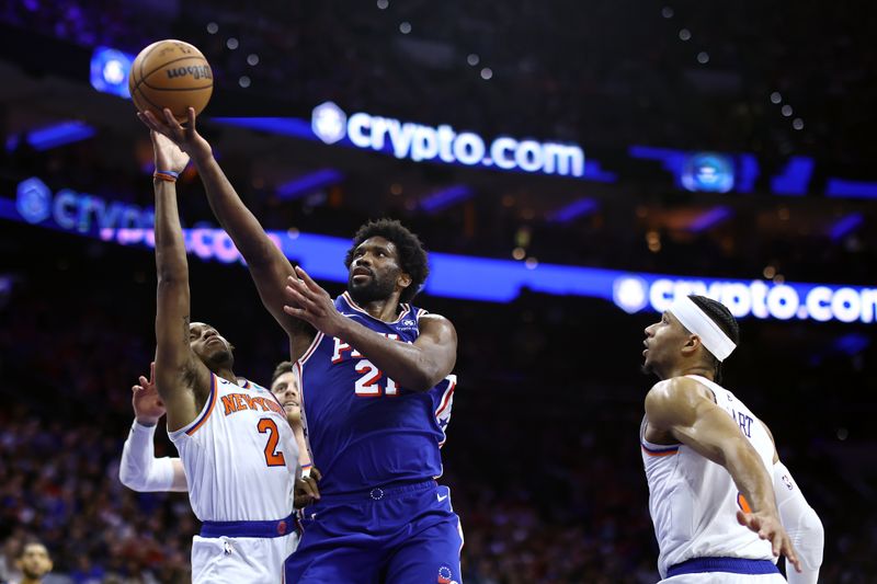 PHILADELPHIA, PENNSYLVANIA - APRIL 25: Joel Embiid #21 of the Philadelphia 76ers shoots a lay up past Miles McBride #2 of the New York Knicks during the third quarter of game three of the Eastern Conference First Round Playoffs at the Wells Fargo Center on April 25, 2024 in Philadelphia, Pennsylvania. NOTE TO USER: User expressly acknowledges and agrees that, by downloading and/or using this Photograph, user is consenting to the terms and conditions of the Getty Images License Agreement. (Photo by Tim Nwachukwu/Getty Images)