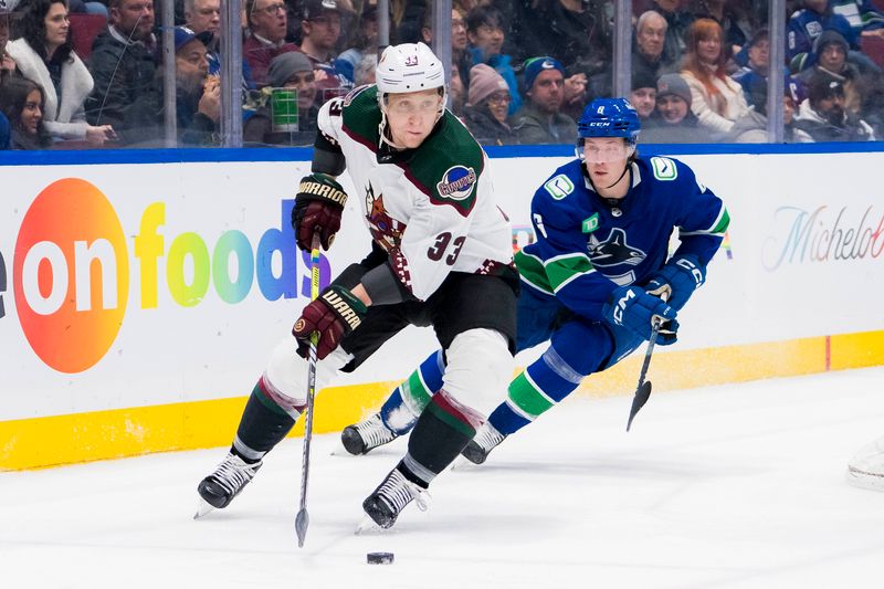 Jan 18, 2024; Vancouver, British Columbia, CAN; Vancouver Canucks forward Brock Boeser (6) pursues Arizona Coyotes defenseman Travis Dermott (33) in the third period at Rogers Arena. Vancouver won 2-1. Mandatory Credit: Bob Frid-USA TODAY Sports