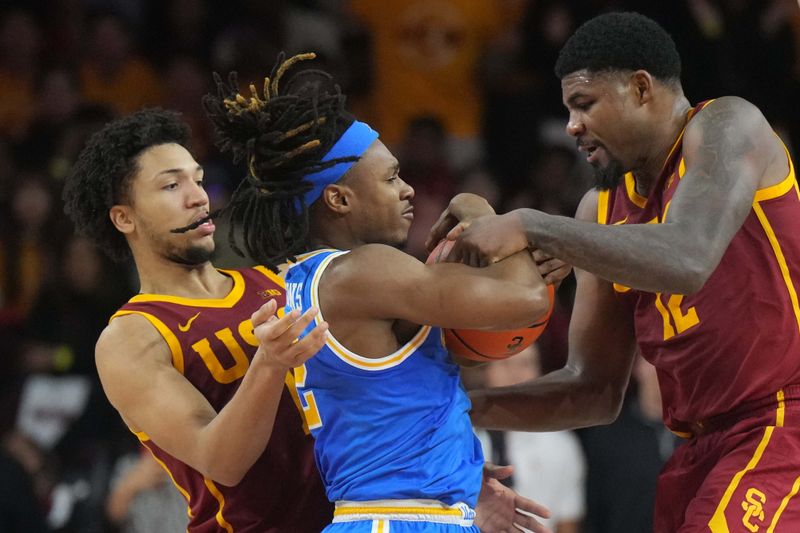 Jan 27, 2025; Los Angeles, California, USA; UCLA Bruins guard Dylan Andrews (2) battles for the ball with Southern California Trojans forward Saint Thomas (0) and forward Rashaun Agee (12) in the second half at Galen Center. Mandatory Credit: Kirby Lee-Imagn Images