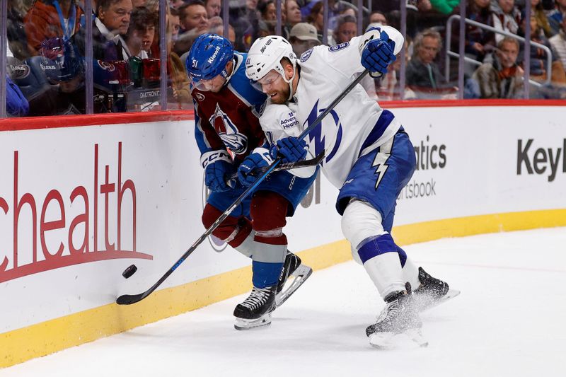 Oct 30, 2024; Denver, Colorado, USA; Colorado Avalanche right wing Nikolai Kovalenko (51) and Tampa Bay Lightning defenseman Erik Cernak (81) battle for the puck in the second period at Ball Arena. Mandatory Credit: Isaiah J. Downing-Imagn Images