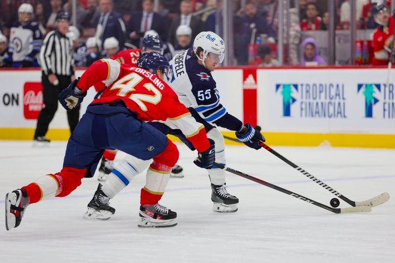 Nov 24, 2023; Sunrise, Florida, USA; Winnipeg Jets center Mark Scheifele (55) moves the puck against Florida Panthers defenseman Gustav Forsling (42) during the first period at Amerant Bank Arena. Mandatory Credit: Sam Navarro-USA TODAY Sports