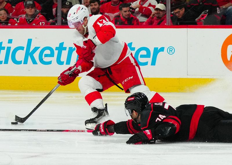 Jan 19, 2024; Raleigh, North Carolina, USA;  Carolina Hurricanes defenseman Jaccob Slavin (74) breaks up the pass attempt by Detroit Red Wings right wing Daniel Sprong (17) during the second period at PNC Arena. Mandatory Credit: James Guillory-USA TODAY Sports