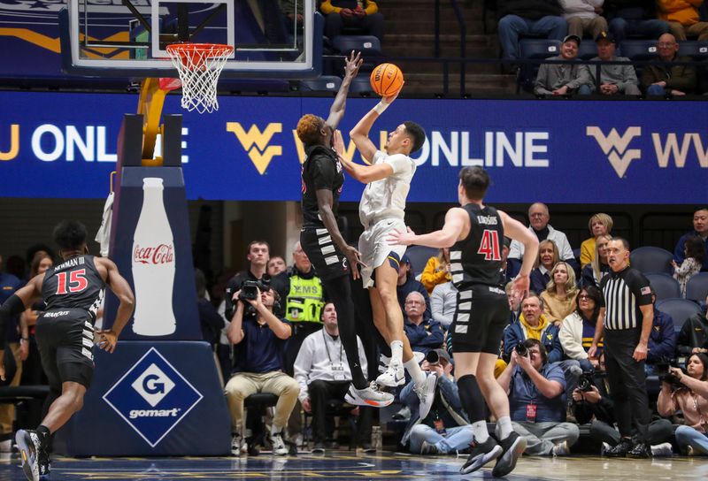 Jan 31, 2024; Morgantown, West Virginia, USA; West Virginia Mountaineers center Jesse Edwards (7) shoots against Cincinnati Bearcats forward Aziz Bandaogo (55) during the first half at WVU Coliseum. Mandatory Credit: Ben Queen-USA TODAY Sports