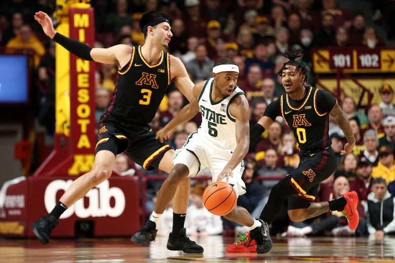 Feb 6, 2024; Minneapolis, Minnesota, USA; Michigan State Spartans guard Tre Holloman (5) dribbles as Minnesota Golden Gophers forward Dawson Garcia (3) and guard Elijah Hawkins (0) defend during the first half at Williams Arena. Mandatory Credit: Matt Krohn-USA TODAY Sports