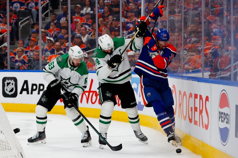 May 25, 2025; Edmonton, Alberta, CAN; Dallas Stars right wing Evgenii Dadonov (63) and left wing Jamie Benn (14) and Edmonton Oilers defenseman John Klingberg (36) battle for the puck during the second period in game three of the Western Conference Final of the 2025 Stanley Cup Playoffs at Rogers Place. Mandatory Credit: Perry Nelson-Imagn Images