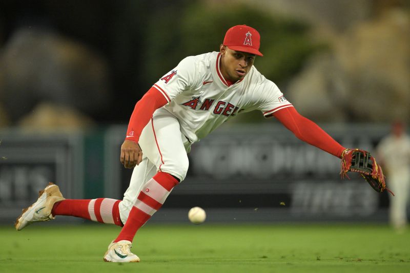 Sep 23, 2025; Anaheim, California, USA;  Kansas City Royals second baseman Adam Frazier (26) singles past Los Angeles Angels second baseman Christian Moore (4) during the fourth inning at Angel Stadium. Mandatory Credit: Jayne Kamin-Oncea-Imagn Images