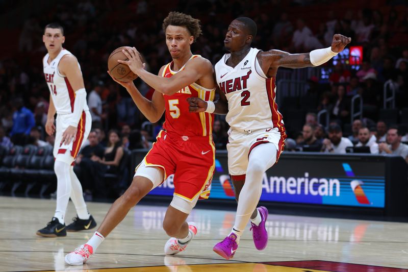 MIAMI, FLORIDA - OCTOBER 16: Dyson Daniels #5 of the Atlanta Hawks drives against Terry Rozier #2 of the Miami Heat during the second quarter of a preseason game at Kaseya Center on October 16, 2024 in Miami, Florida. NOTE TO USER: User expressly acknowledges and agrees that, by downloading and or using this photograph, User is consenting to the terms and conditions of the Getty Images License Agreement. (Photo by Megan Briggs/Getty Images)