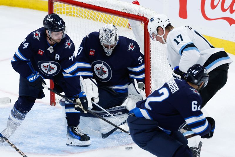 Nov 5, 2024; Winnipeg, Manitoba, CAN;  Winnipeg Jets goalie Connor Hellebuyck (37) makes a save on a shot by Utah Hockey Club forward Nick Bjugstad (17) as Winnipeg Jets defenseman Josh Morrissey (44) looks to clear the rebound during the third period at Canada Life Centre. Mandatory Credit: Terrence Lee-Imagn Images