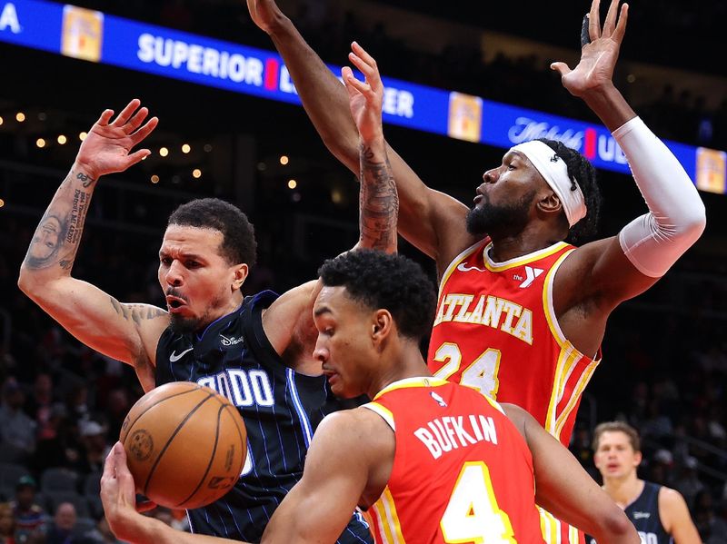 ATLANTA, GEORGIA - FEBRUARY 25:  Bruno Fernando #24 defends as Cole Anthony #50 of the Orlando Magic has the ball stripped away by Kobe Bufkin #4 of the Atlanta Hawks during the first quarter at State Farm Arena on February 25, 2024 in Atlanta, Georgia.  NOTE TO USER: User expressly acknowledges and agrees that, by downloading and/or using this photograph, user is consenting to the terms and conditions of the Getty Images License Agreement.  (Photo by Kevin C. Cox/Getty Images)