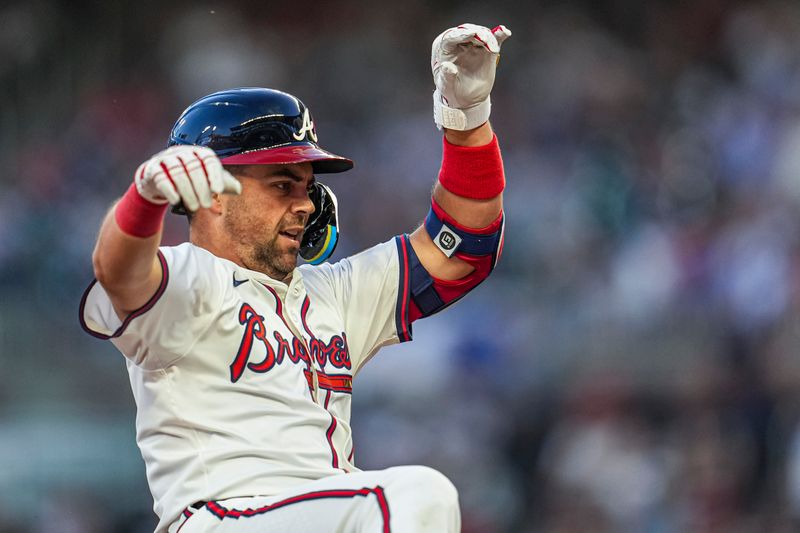 Aug 20, 2024; Cumberland, Georgia, USA; Atlanta Braves left fielder Whit Merrifield (15) slides into third base after hitting a triple against the Philadelphia Phillies during the third inning at Truist Park. Mandatory Credit: Dale Zanine-USA TODAY Sports