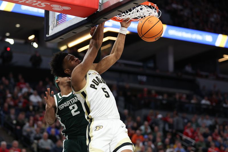 Mar 15, 2024; Minneapolis, MN, USA; Purdue Boilermakers guard Myles Colvin (5) dunks as Michigan State Spartans guard Tyson Walker (2) defends during the first half at Target Center. Mandatory Credit: Matt Krohn-USA TODAY Sports