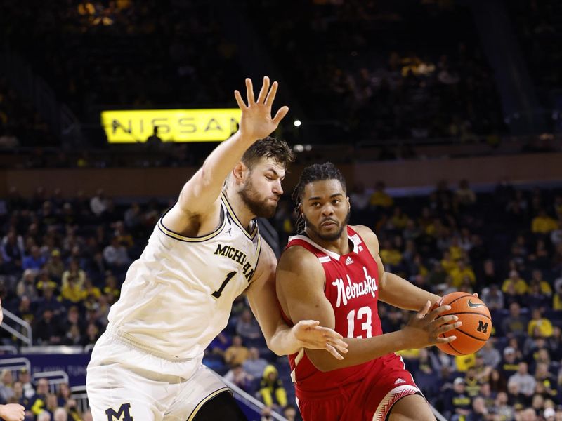 Feb 8, 2023; Ann Arbor, Michigan, USA;  Nebraska Cornhuskers forward Derrick Walker (13) dribbles defended by Michigan Wolverines center Hunter Dickinson (1) in the second half at Crisler Center. Mandatory Credit: Rick Osentoski-USA TODAY Sports