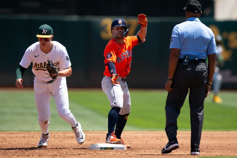 Jul 24, 2024; Oakland, California, USA; Houston Astros second baseman Jose Altuve (27) reacts after being tagged out by Oakland Athletics second baseman Zack Gelof (20) as Altuve tried to stretch a RBI single into a double during the second inning at Oakland-Alameda County Coliseum. Umpire is CB Bucknor. Mandatory Credit: D. Ross Cameron-USA TODAY Sports