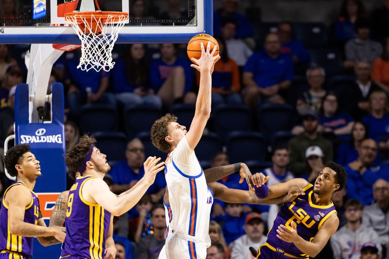 Feb 13, 2024; Gainesville, Florida, USA; Florida Gators center Micah Handlogten (3) grabs a rebound over LSU Tigers guard Jordan Wright (6) and LSU Tigers forward Will Baker (9) during the second half at Exactech Arena at the Stephen C. O'Connell Center. Mandatory Credit: Matt Pendleton-USA TODAY Sports