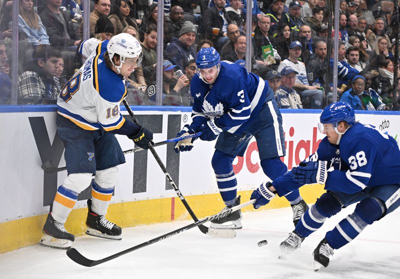 Jan 3, 2023; Toronto, Ontario, CAN; St. Louis Blues forward Robert Thomas (18) passes the puck away from Toronto Maple Leafs defensemen Justin Holl (3) and Rasmus Sandin (38) in the second period at Scotiabank Arena. Mandatory Credit: Dan Hamilton-USA TODAY Sports