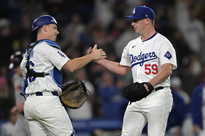 Apr 2, 2024; Los Angeles, California, USA;  Los Angeles Dodgers relief pitcher Evan Phillips (59) shakes hands with catcher Will Smith (16) after he earned a save in the ninth inning against the San Francisco Giants at Dodger Stadium. Mandatory Credit: Jayne Kamin-Oncea-USA TODAY Sports
