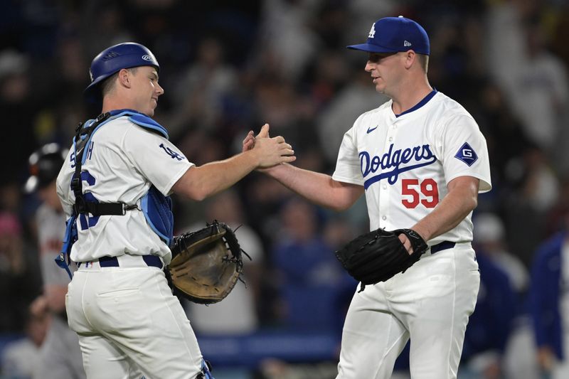 Apr 2, 2024; Los Angeles, California, USA;  Los Angeles Dodgers relief pitcher Evan Phillips (59) shakes hands with catcher Will Smith (16) after he earned a save in the ninth inning against the San Francisco Giants at Dodger Stadium. Mandatory Credit: Jayne Kamin-Oncea-USA TODAY Sports