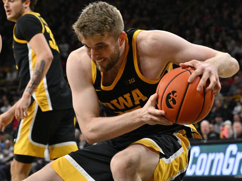 Feb 17, 2024; Iowa City, Iowa, USA; Iowa Hawkeyes forward Ben Krikke (23) grabs a rebound against the Wisconsin Badgers during the first half at Carver-Hawkeye Arena. Mandatory Credit: Jeffrey Becker-USA TODAY Sports