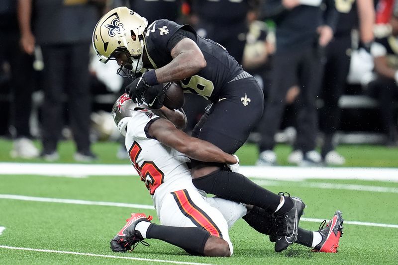 New Orleans Saints wide receiver Bub Means, top, runs against Tampa Bay Buccaneers cornerback Jamel Dean during the first half of an NFL football game in New Orleans, Sunday, Oct. 13, 2024. (AP Photo/Michael Conroy)