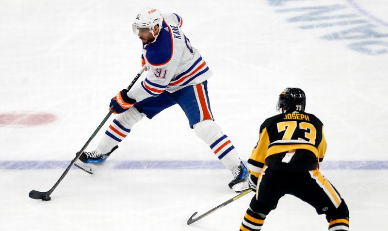 Mar 10, 2024; Pittsburgh, Pennsylvania, USA;  Edmonton Oilers left wing Evander Kane (91) moves the puck against Pittsburgh Penguins defenseman Pierre-Olivier Joseph (73) during the third period at PPG Paints Arena.The Oilers won 4-0. Mandatory Credit: Charles LeClaire-USA TODAY Sports